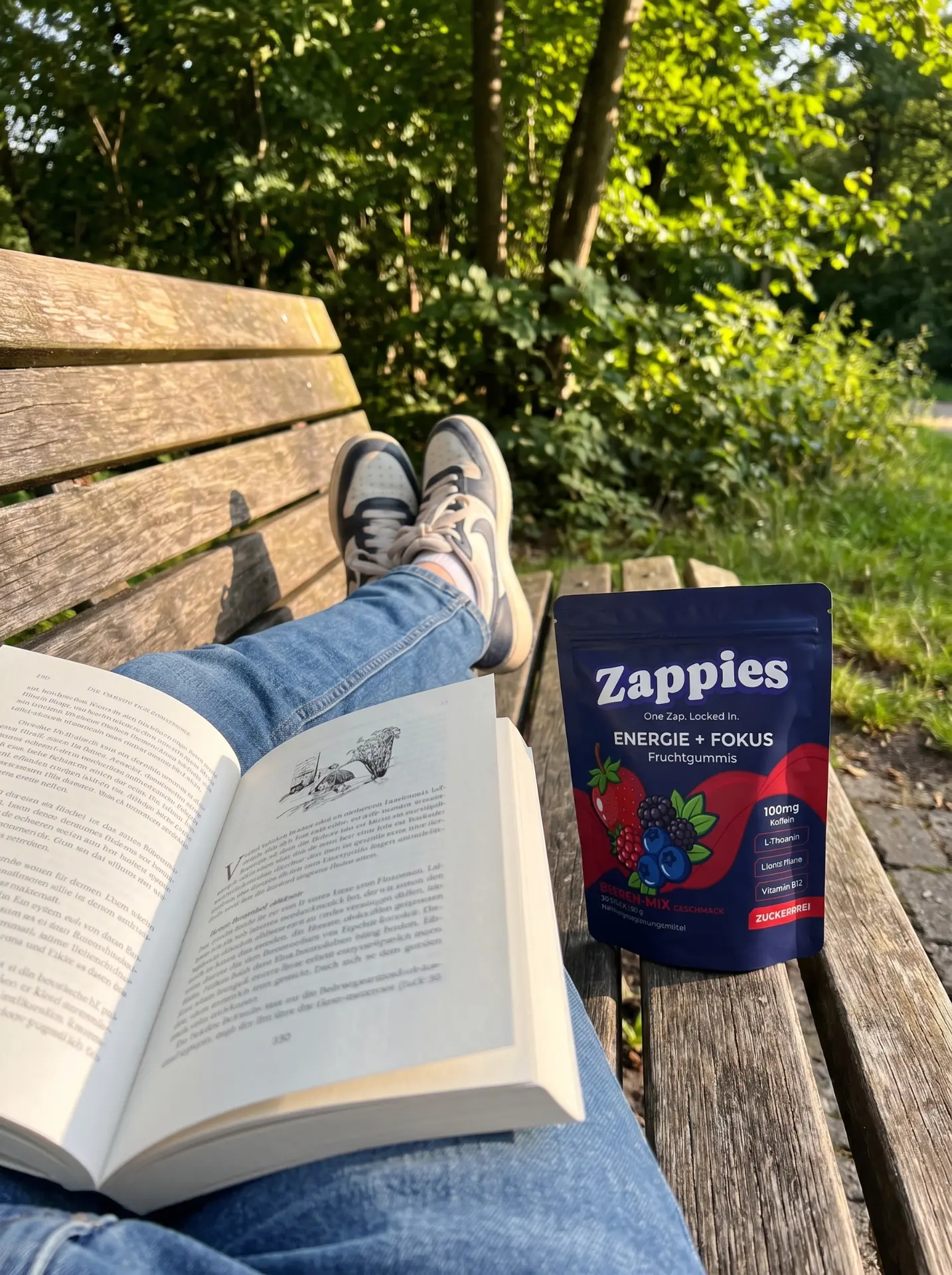 ZAPPIES Beutel auf einer Parkbank neben einem aufgeschlagenen Buch
